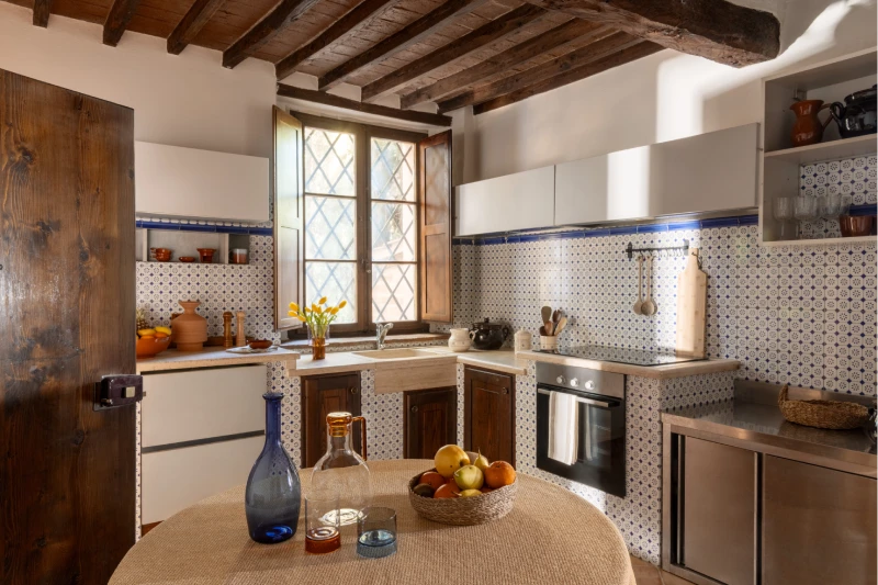 Rustic kitchen at the Villa Annex Adults Only with exposed beams and patterned tiles in the Crete Senesi - Castello di Leonina, BZAR hotels in Tuscany