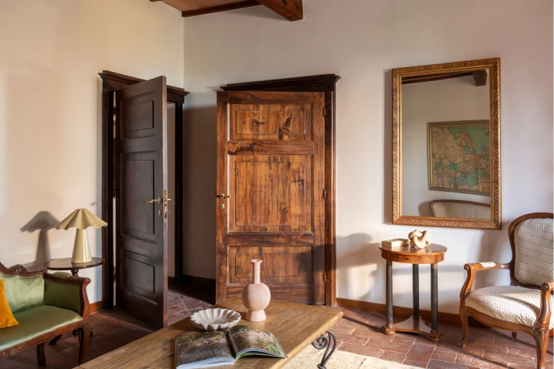 Elegant entryway at the Villa Annex Adults Only with antique wooden door, gilded mirror and period furnishings in Asciano - Castello di Leonina, BZAR hotels in Tuscany