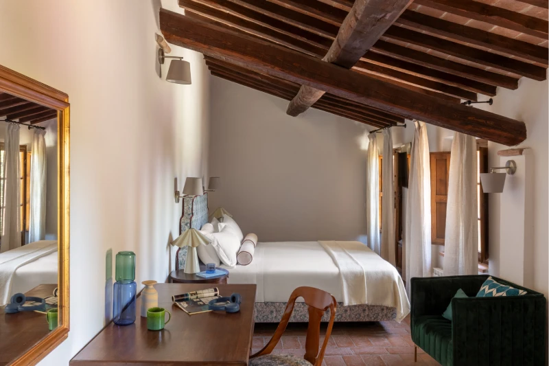 Beamed-ceiling room at the Villa Annex Adults Only with writing desk and green armchair, Tuscan style near Asciano - Castello di Leonina, BZAR hotels in Tuscany