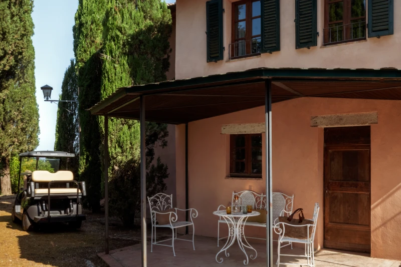 Exterior of the Villa Annex Adults Only with pink Tuscan facade, covered porch and cypresses near Asciano - Castello di Leonina, BZAR hotels in Tuscany